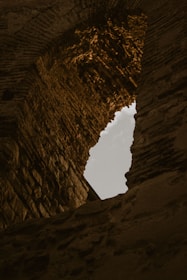 An ancient, rune-covered stone archway glowing faintly under a twilight sky.