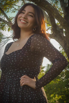 Happy customer wearing a vibrant dress, smiling outdoors.