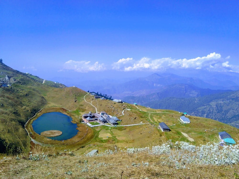 a grassy hill with a lake in the middle of it