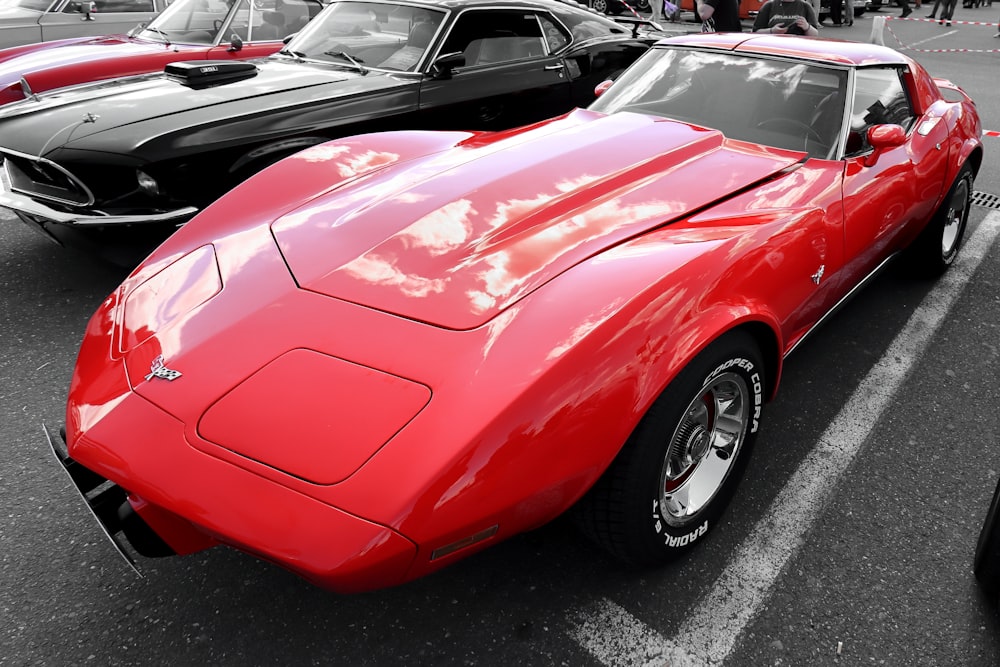 a red car parked in a parking lot next to other cars