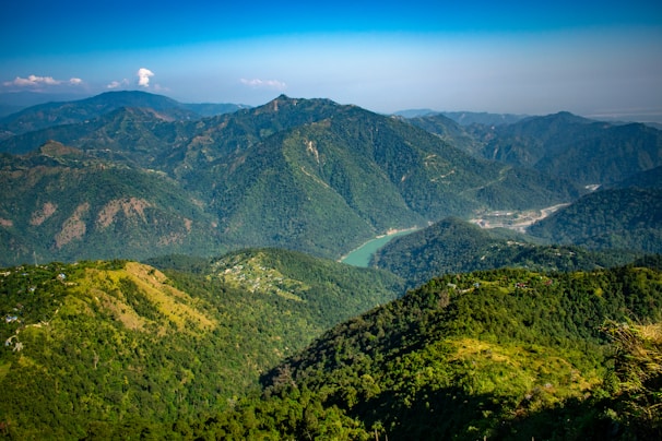 a view of a valley and mountains from the top of a hill