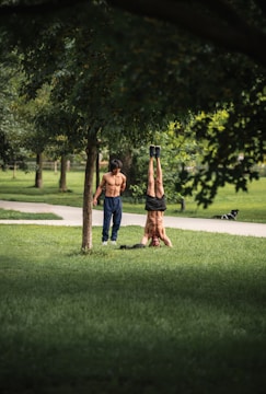 Two friends doing push-ups facing each other in a park.
