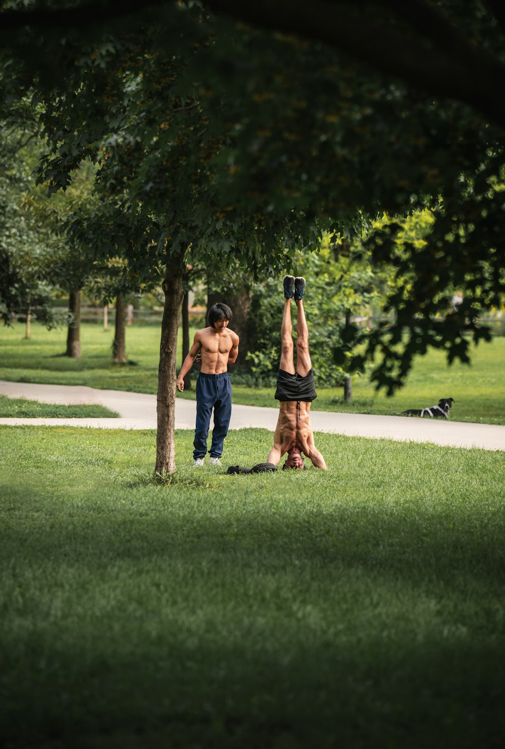 a man and a woman doing a handstand in a park