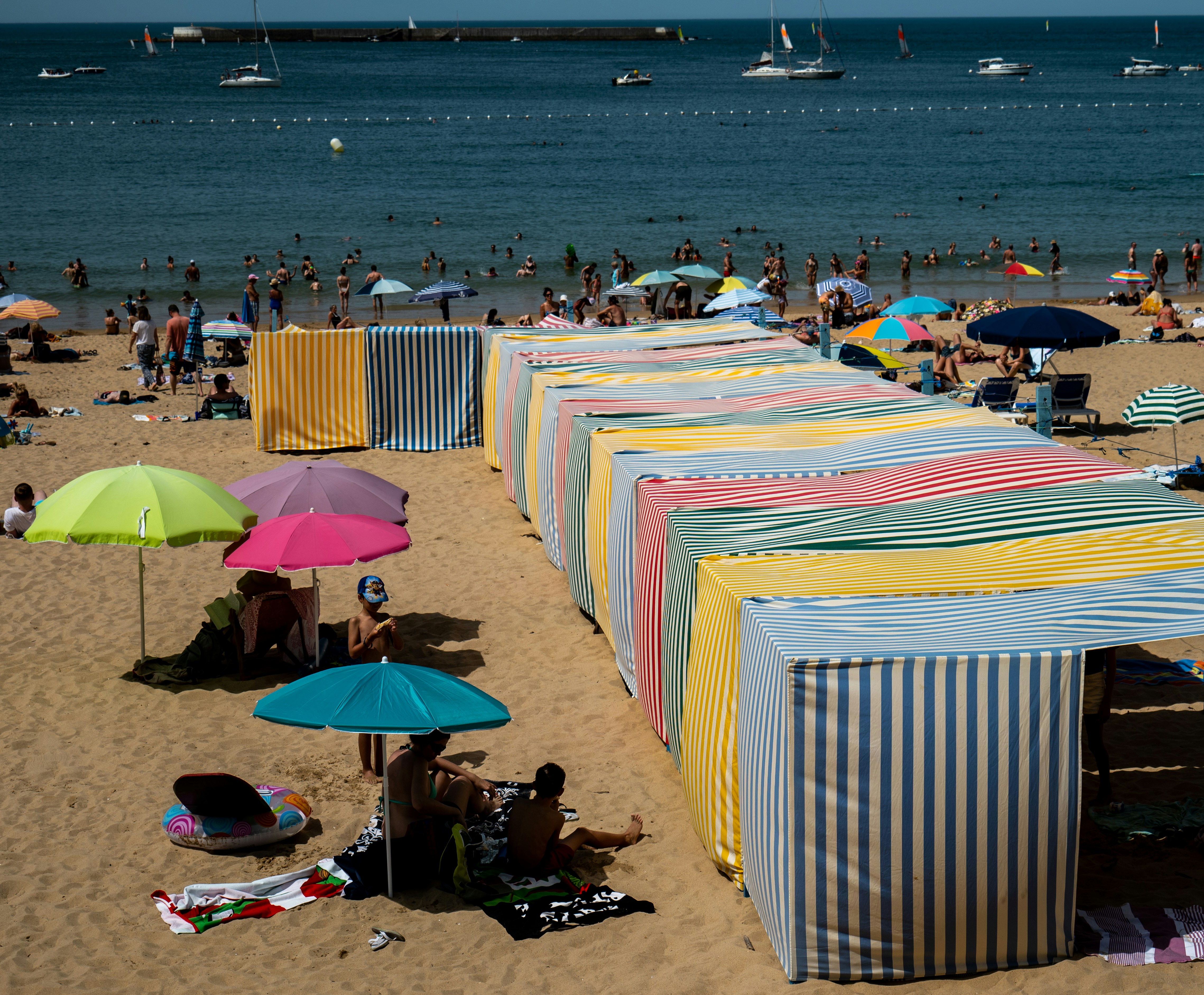 a group of people on a beach with umbrellas