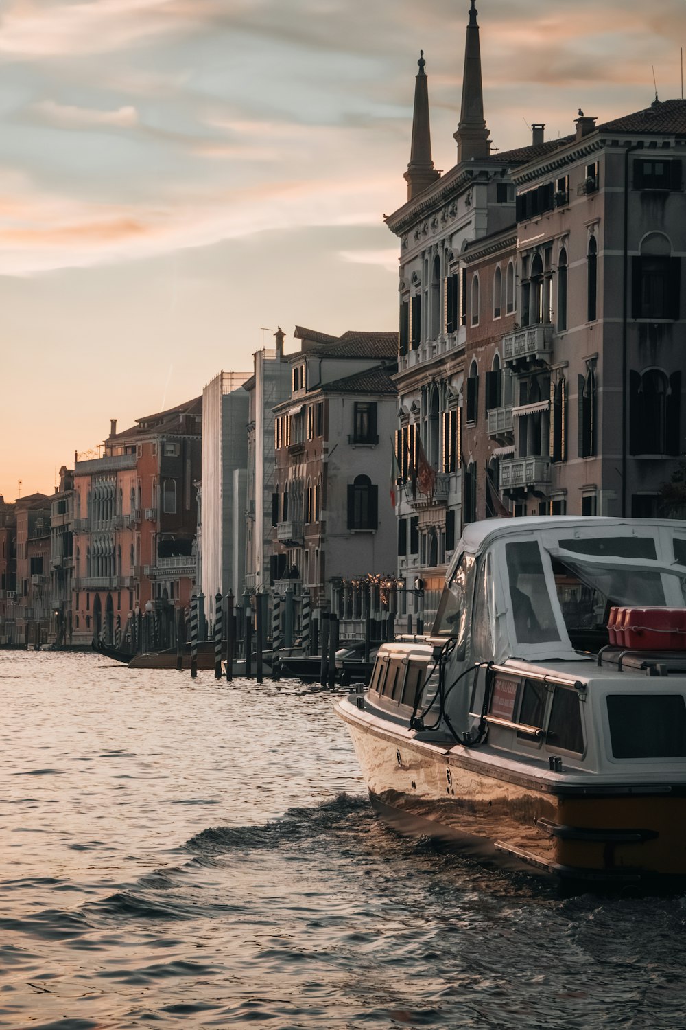 a boat traveling down a river next to tall buildings