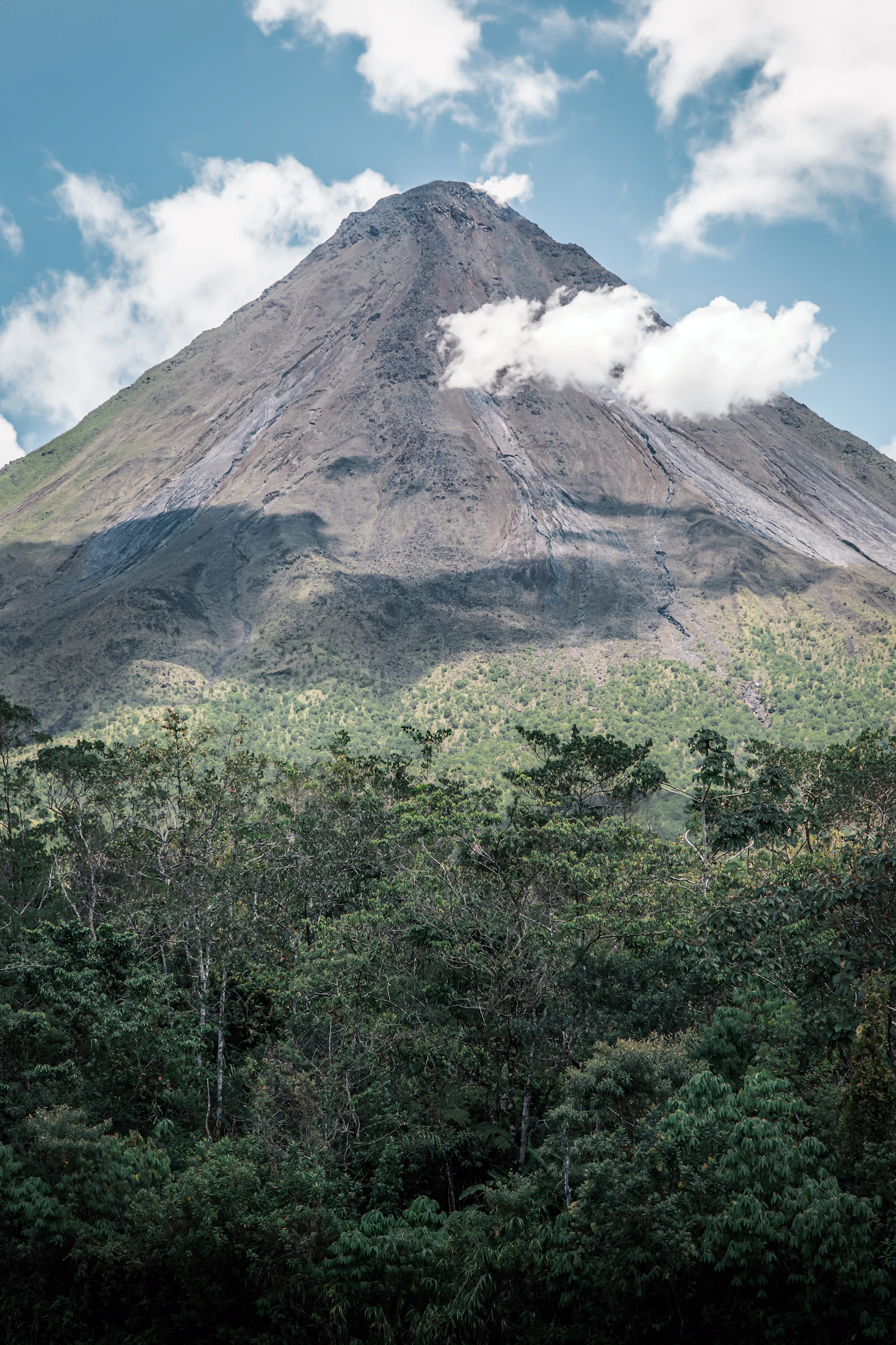 Arenal Volcano rising above dense green forest