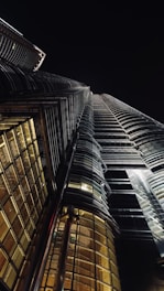 Dramatic night shot of a sleek, illuminated skyscraper piercing the dark sky.