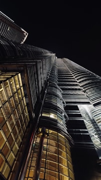 Dramatic night shot of a sleek, illuminated skyscraper piercing the dark sky.