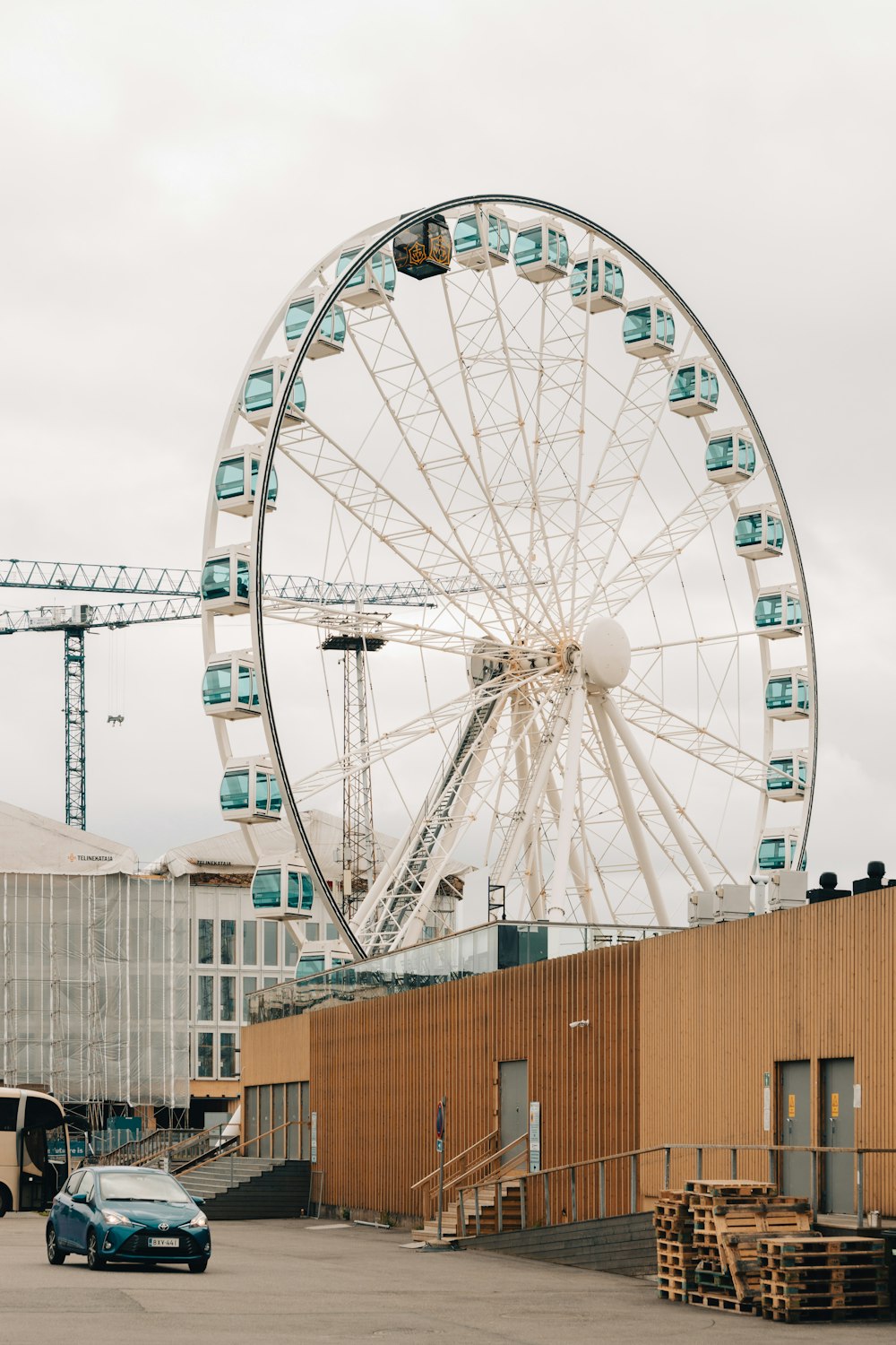 uma grande roda-gigante sentada ao lado de um edifício