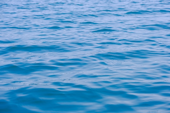 A calm water surface reflecting a clear sky, symbolizing clarity and trust in consulting.