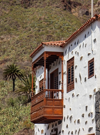 Modern Mallorca home with natural stone facade and wooden accents under bright sunlight.