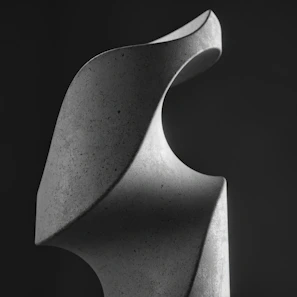 A ceramic sculpture with smooth, flowing curves capturing light elegantly