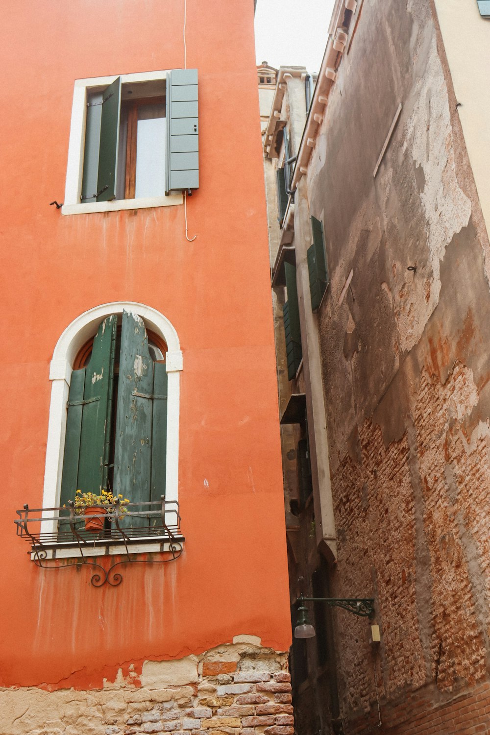 an orange building with a green door and window