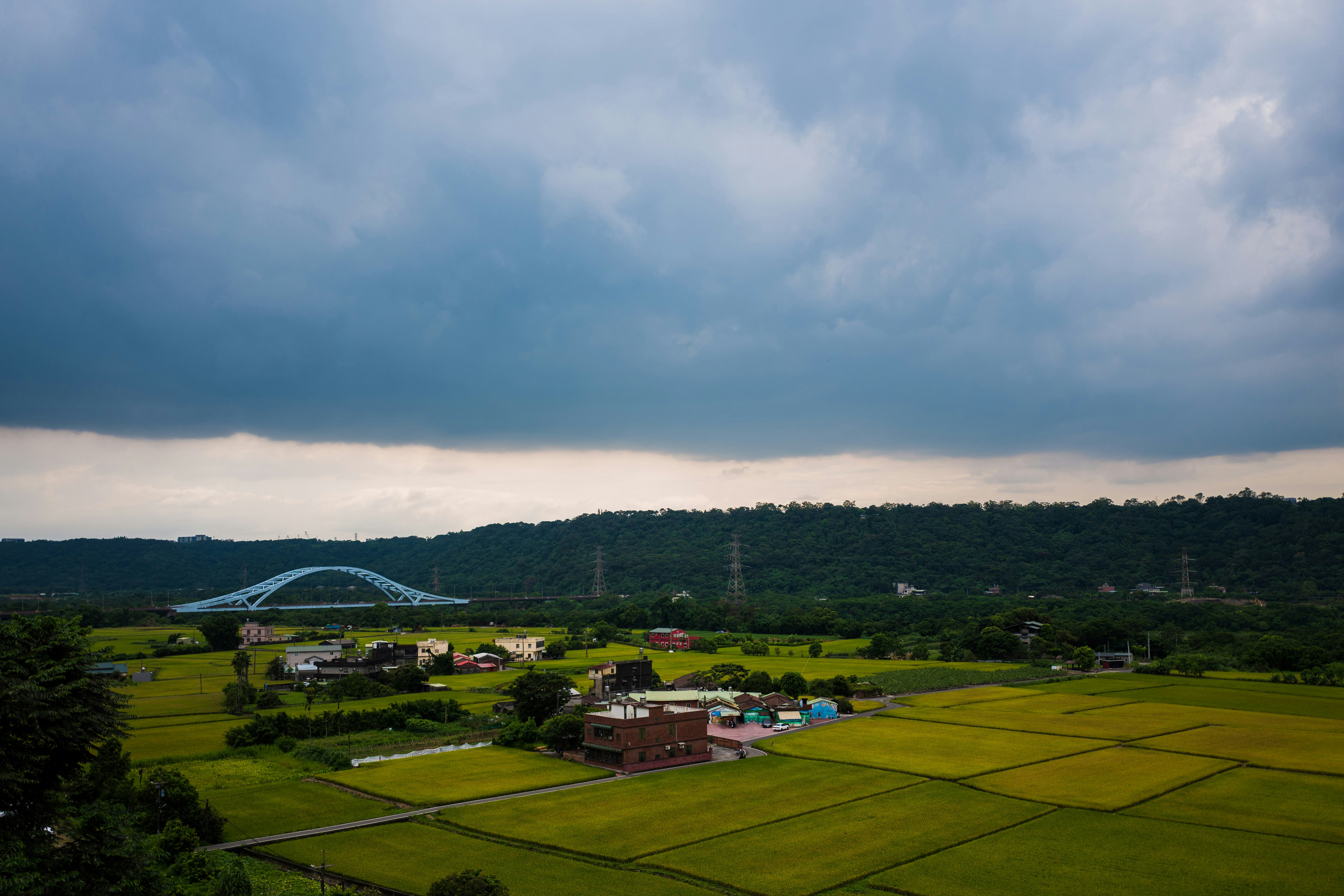 an aerial view of a farm with a bridge in the distance