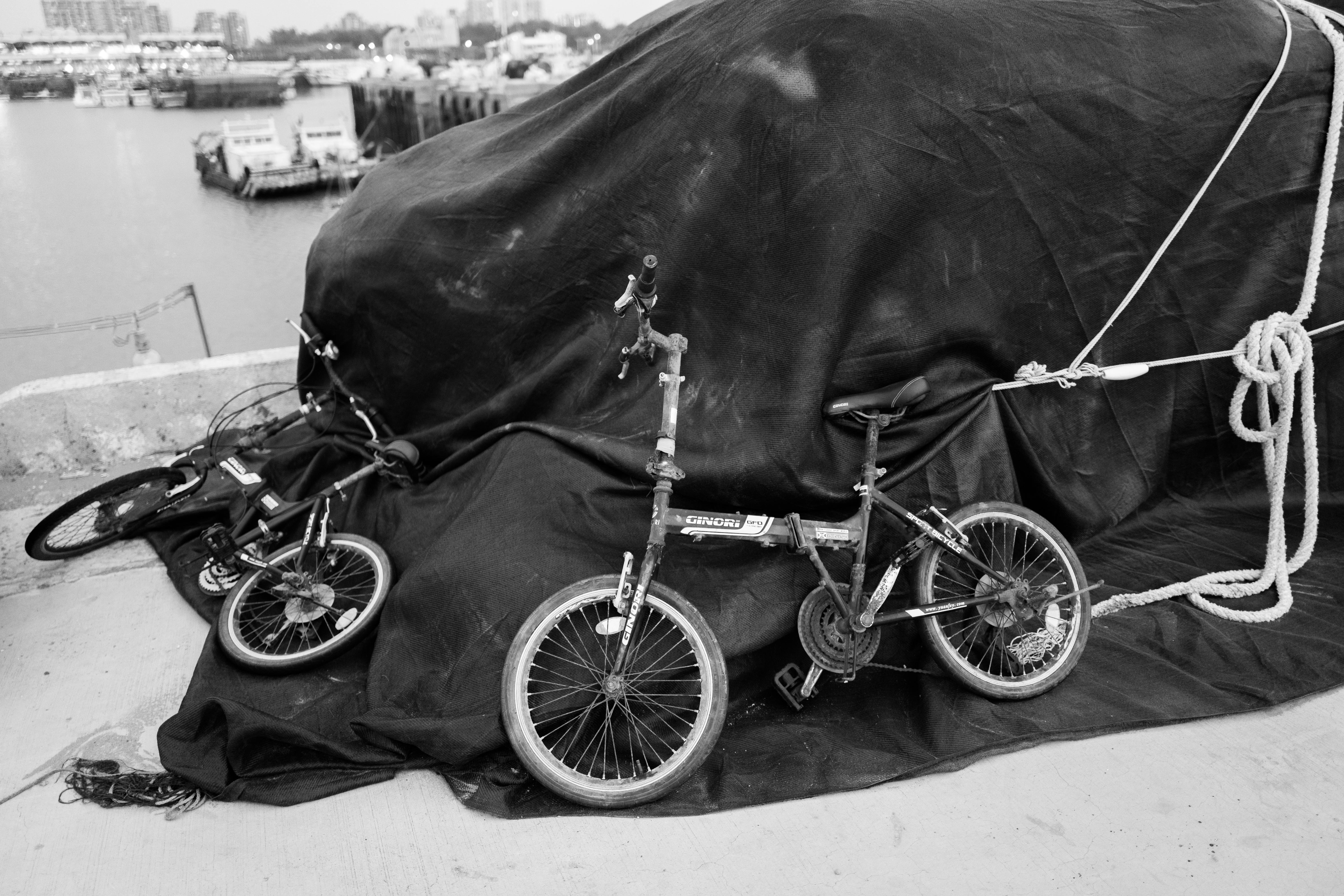 a black and white photo of two bikes wrapped in a tarp
