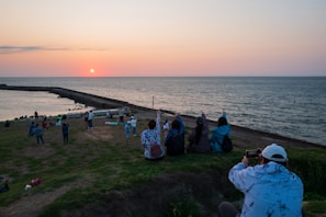 Passengers admiring the panoramic view from a hilltop overlooking the bay at sunset.