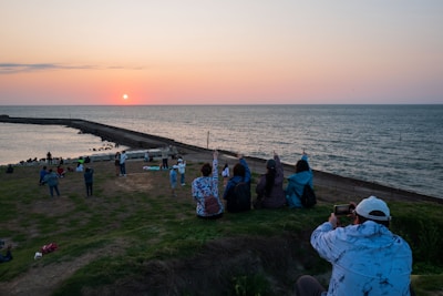 Sunset group circle sharing moments of gratitude by the ocean.