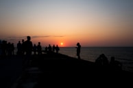 Sunset silhouettes of retreat guests enjoying a mindful meditation on the shore.