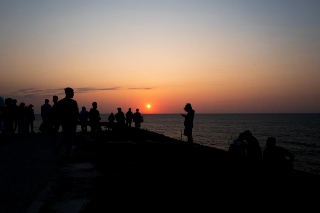 A group of uniformed police officers enjoying a serene coastal sunset together, symbolizing trust and camaraderie.