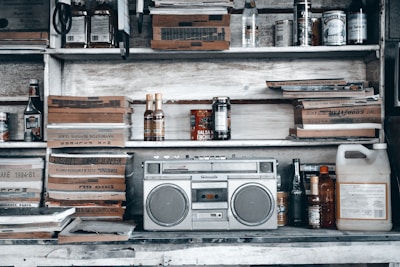 An eclectic shelf filled with retro radios, cassette tapes, and quirky collectibles.