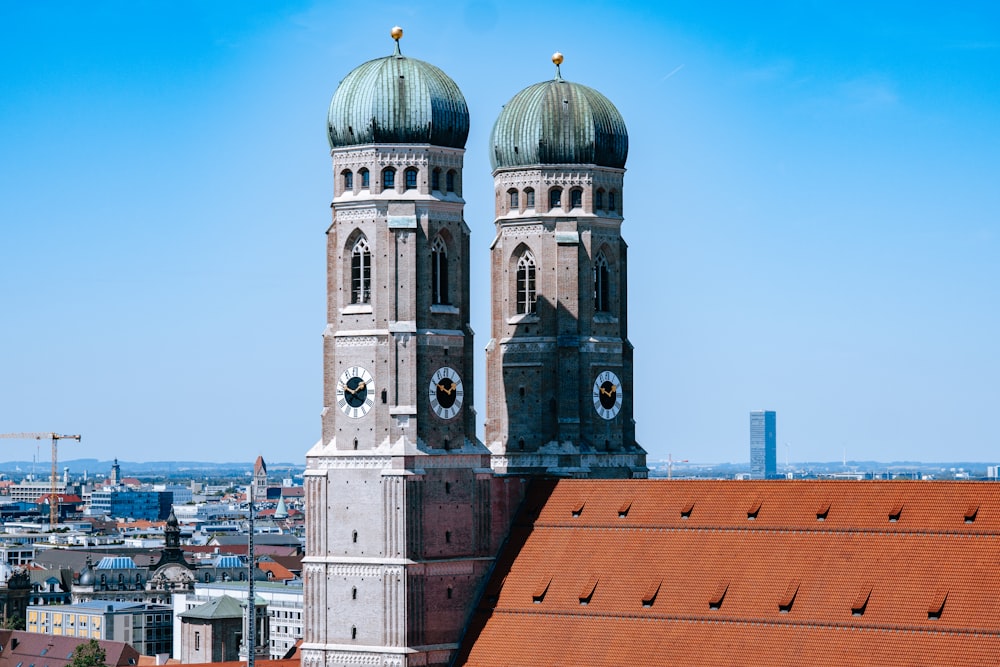 two towers on top of a building with a city in the background