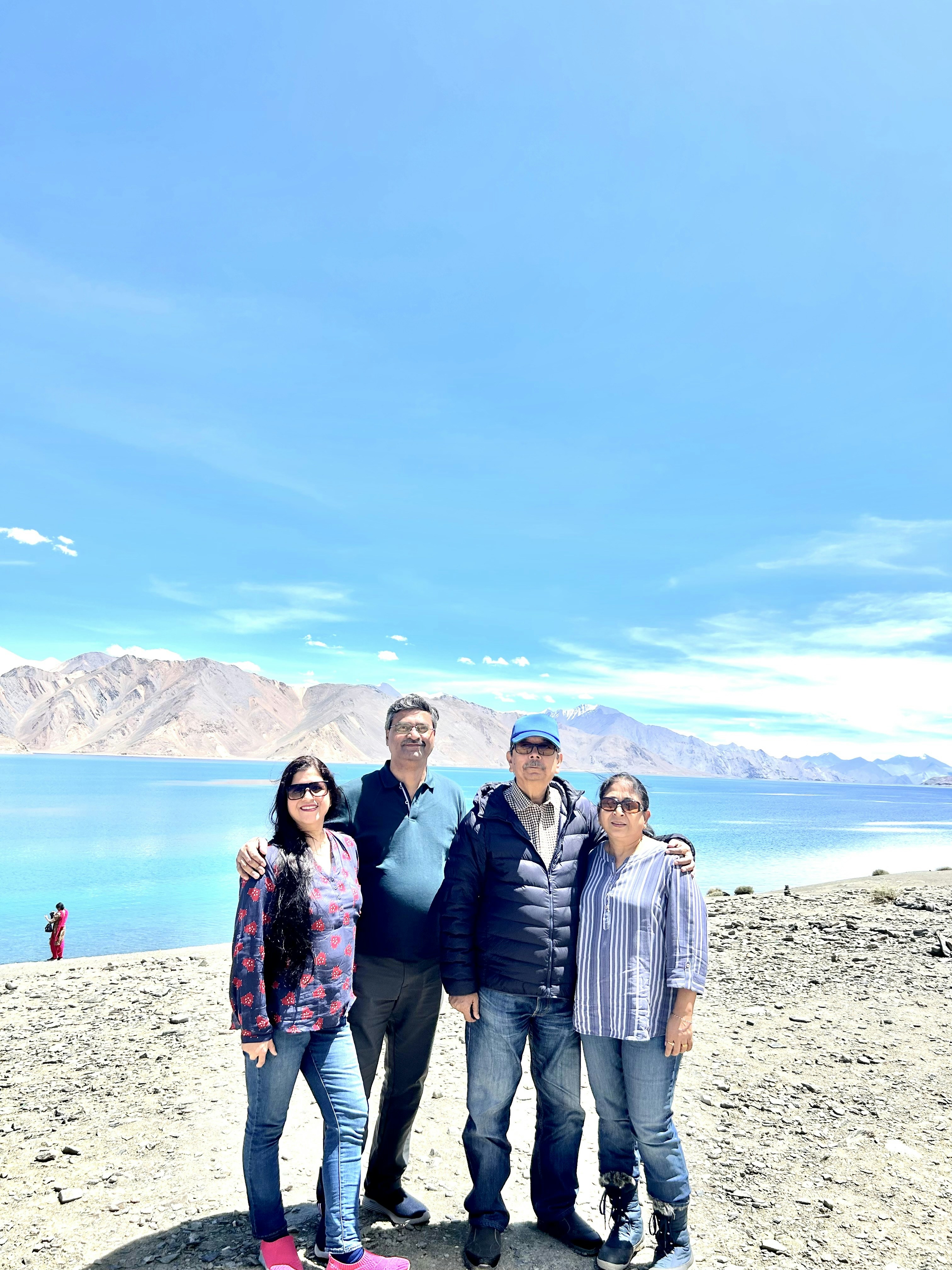 Patel family posing happily at Udaipur City Palace with Lake Pichola in background