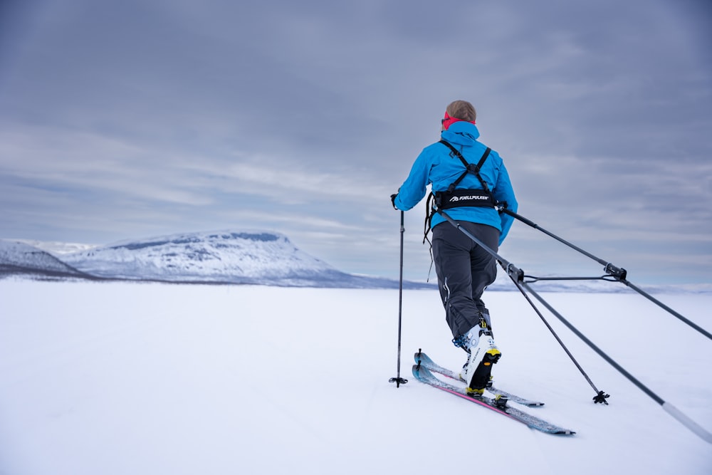 Un hombre montando esquís por una pendiente cubierta de nieve