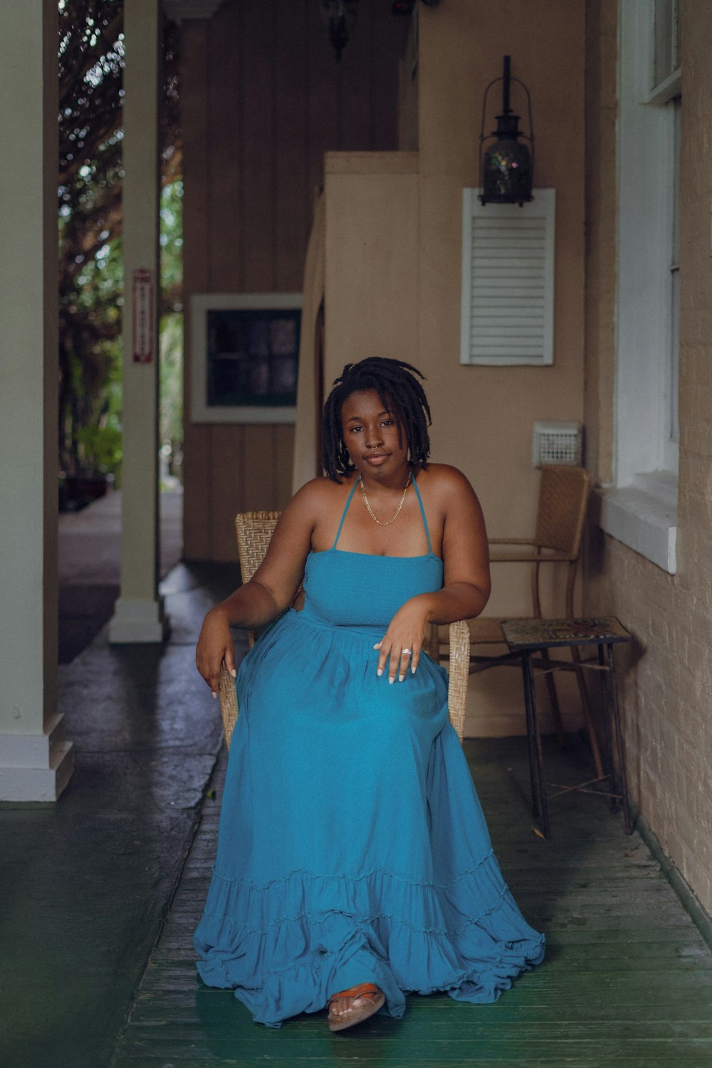 a woman in a blue dress sitting on a chair