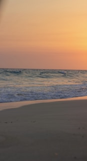 A serene beach scene at sunset showcasing warm earth tones.
