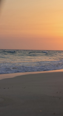 A serene beach scene at sunset showcasing warm earth tones.