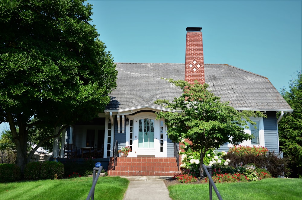 a blue house with a red brick chimney