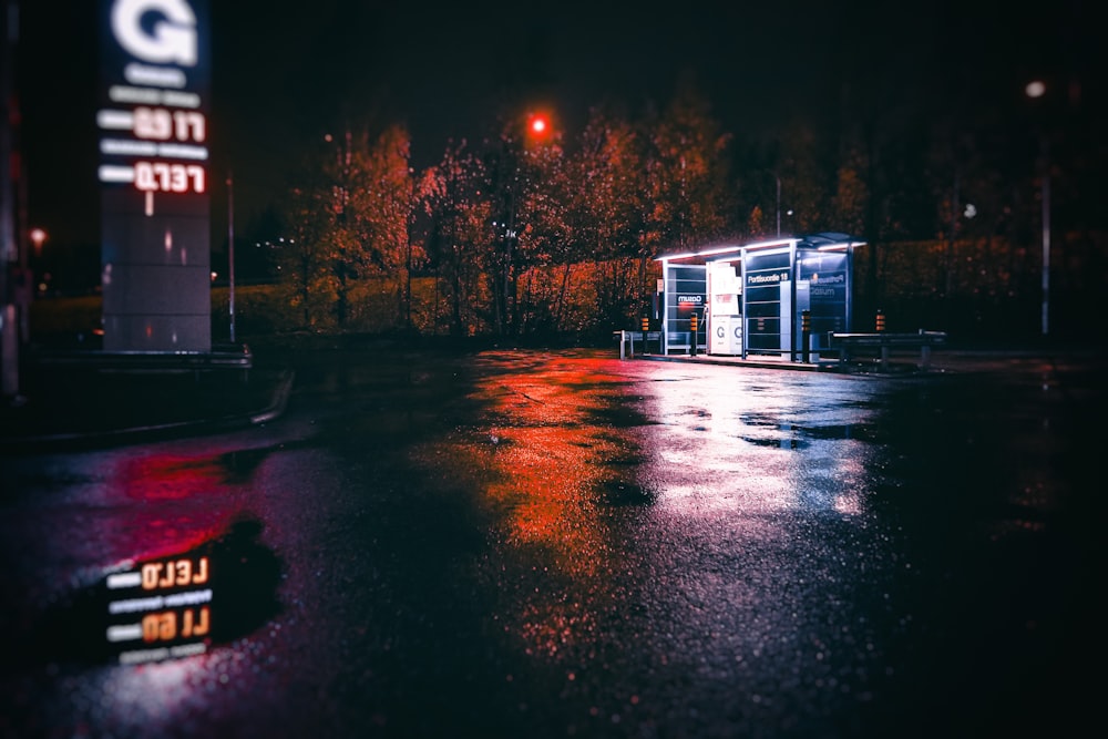 a bus stop sitting on the side of a road at night