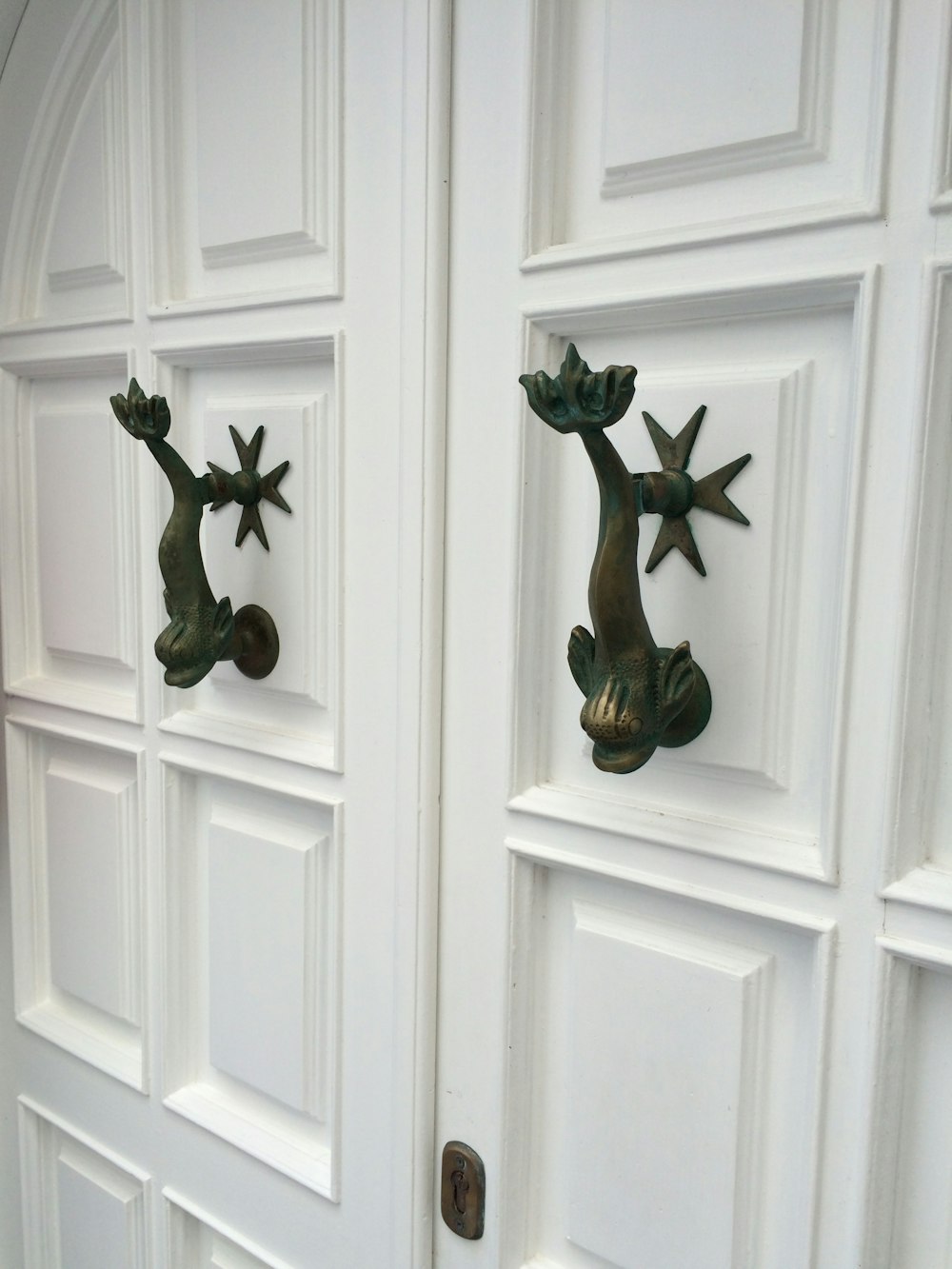 a close up of a metal door handle on a white door