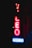 A neon sign glowing in the dark with the words 'VIDEO' and 'BOOKS'. The letters 'VIDEO' are vertically aligned in red, while 'BOOKS' is horizontally aligned in blue. The sign appears to be against a building facade.