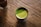 A steaming cup of vibrant green matcha tea on a wooden table with natural light.