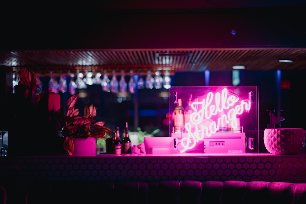 a bar with a neon sign on the counter