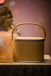 A stylish wireless speaker emitting colorful lights in a cozy room.