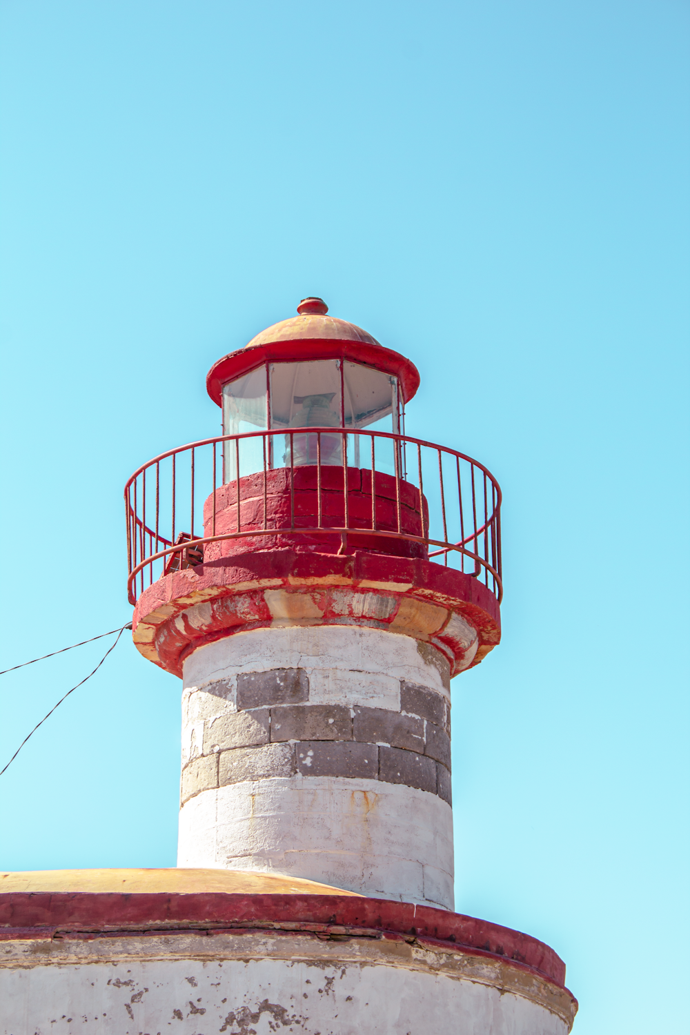 a red and white lighthouse with a blue sky in the background