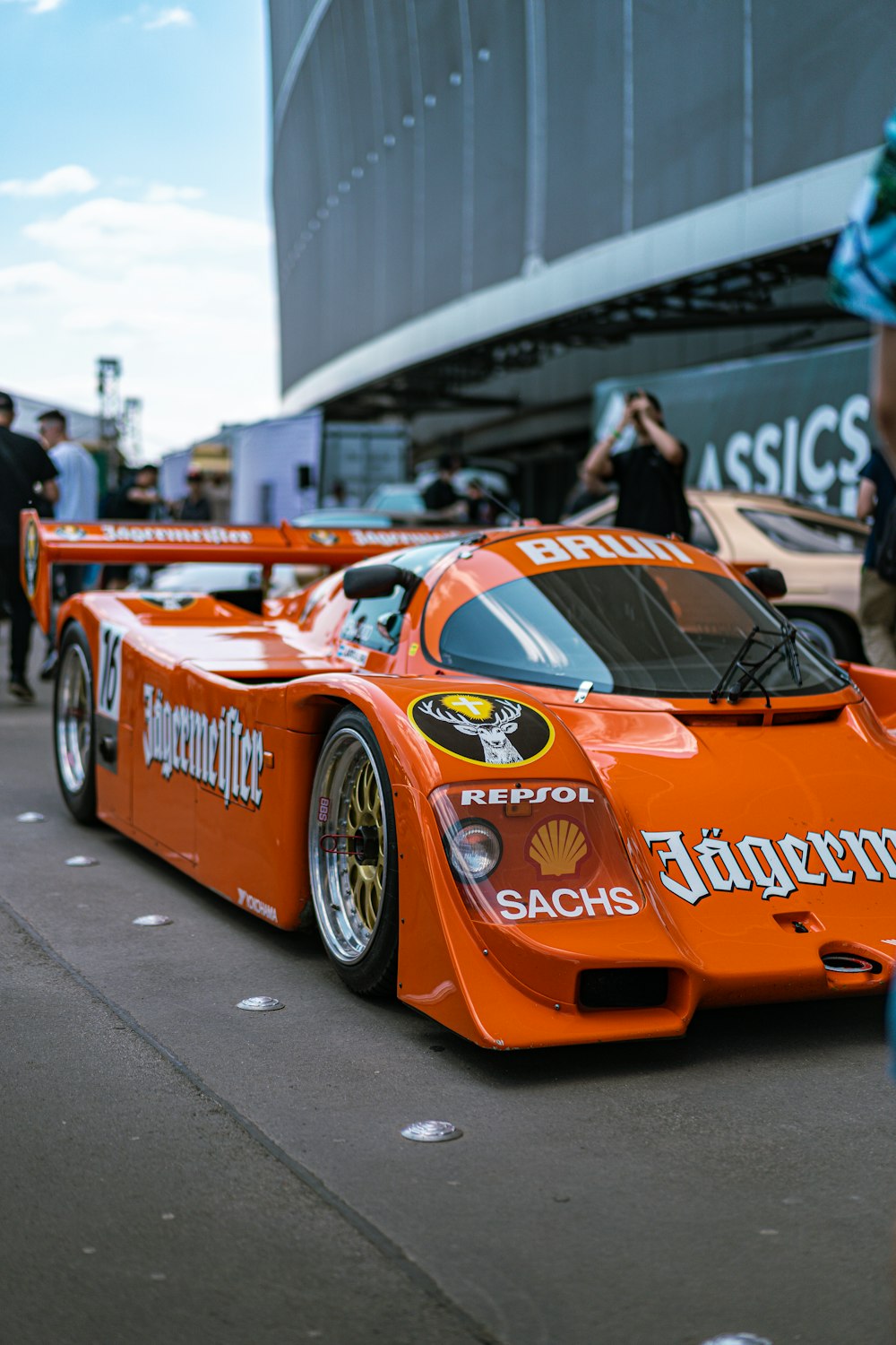 an orange race car parked in front of a building