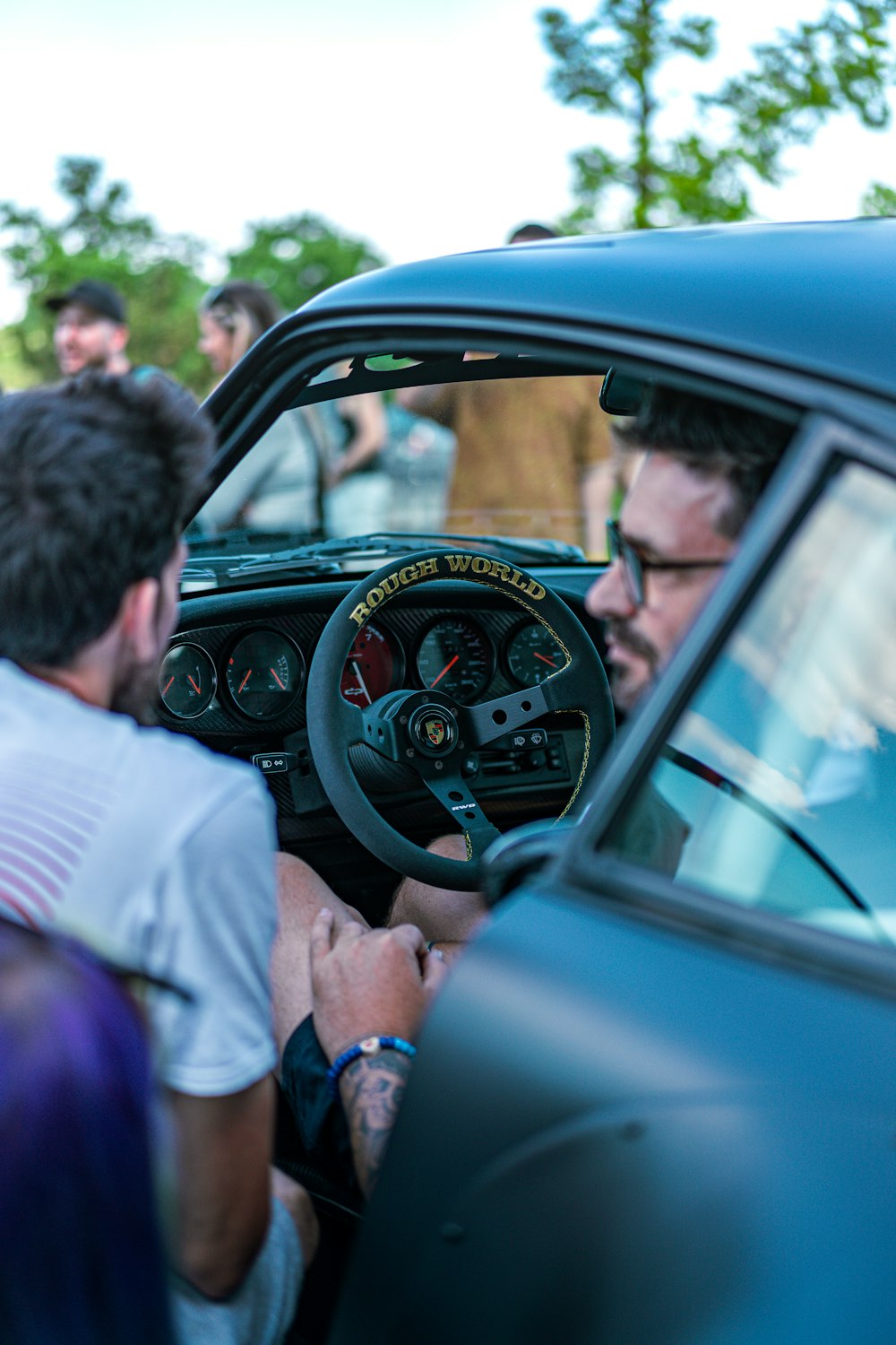 a man sitting in a car with a steering wheel