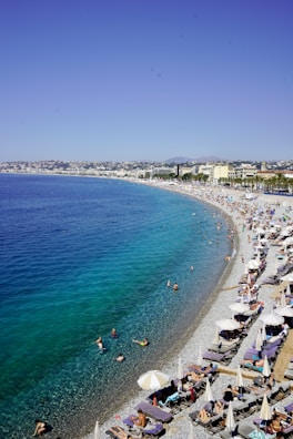 a beach filled with lots of people and umbrellas