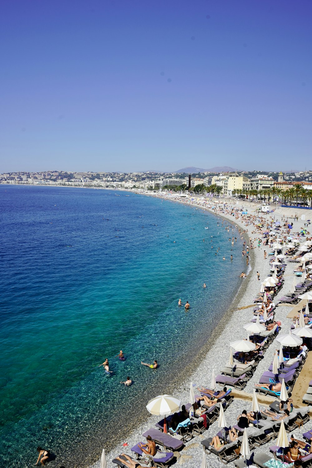 a beach filled with lots of people and umbrellas