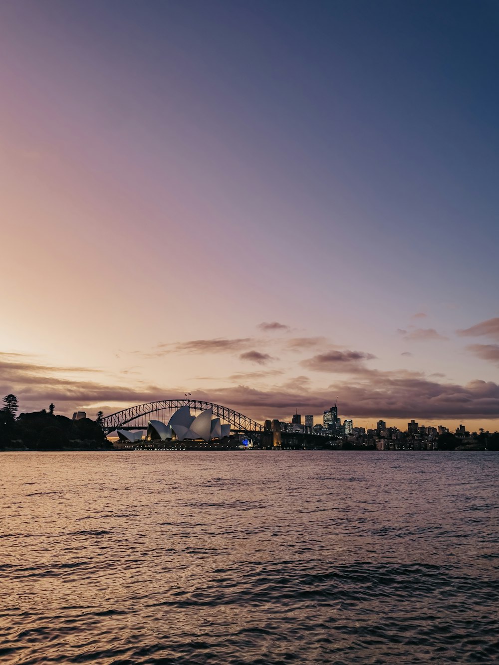 a large body of water with a bridge in the background