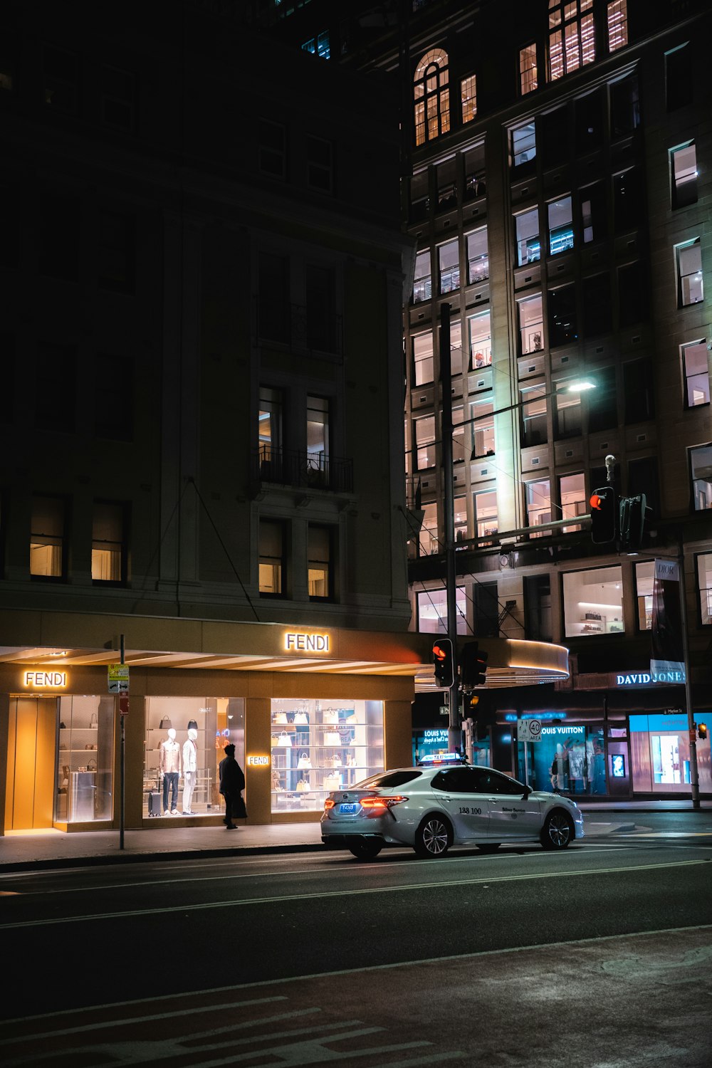 a car parked on the side of a street next to a tall building