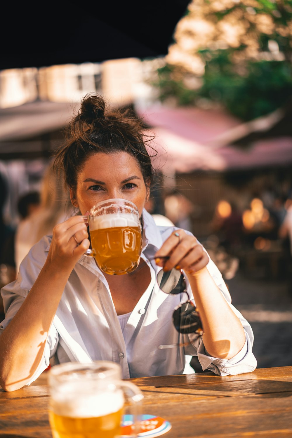 a woman sitting at a table with a glass of beer