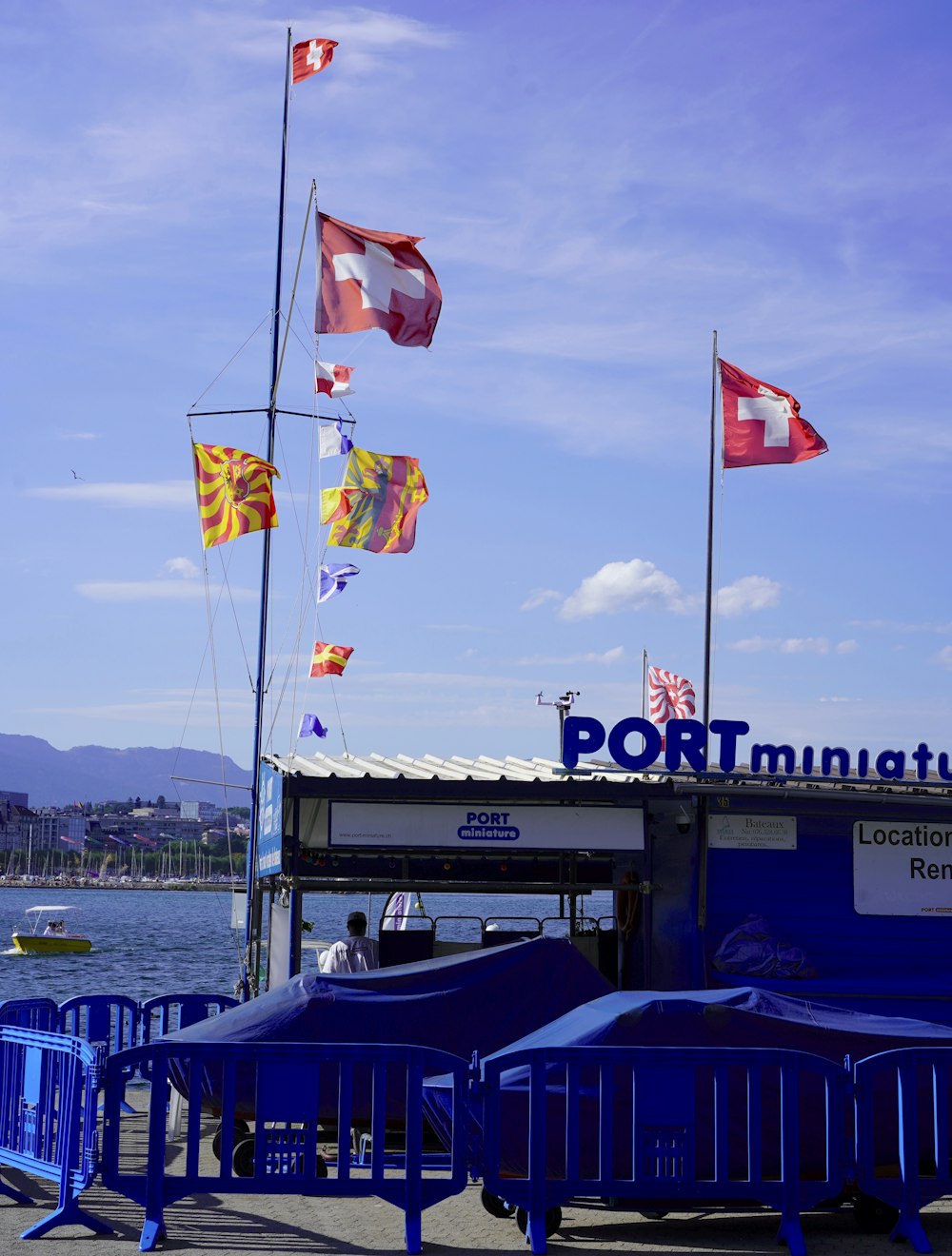 a boat dock with flags flying in the wind