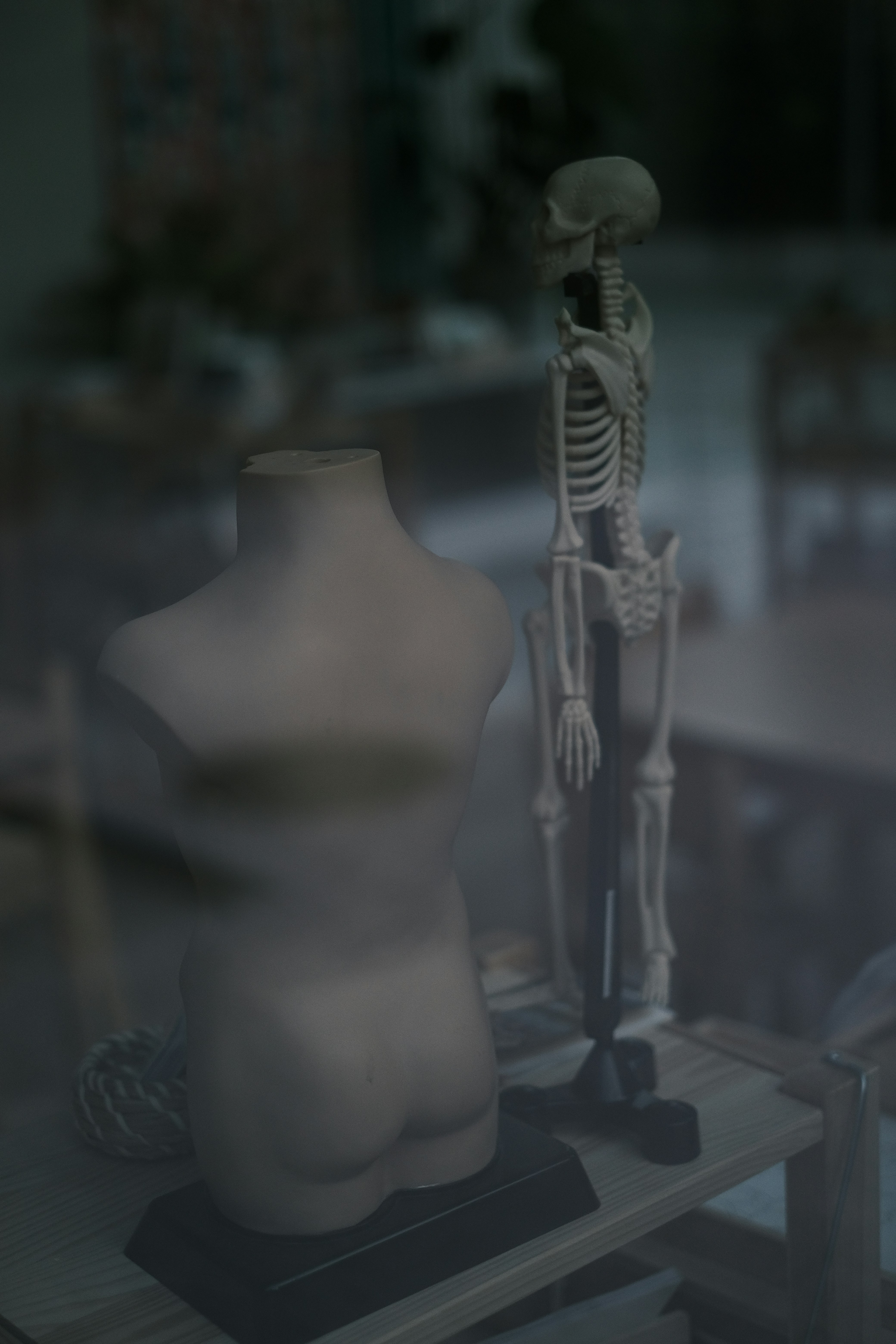a mannequin sitting on top of a wooden table