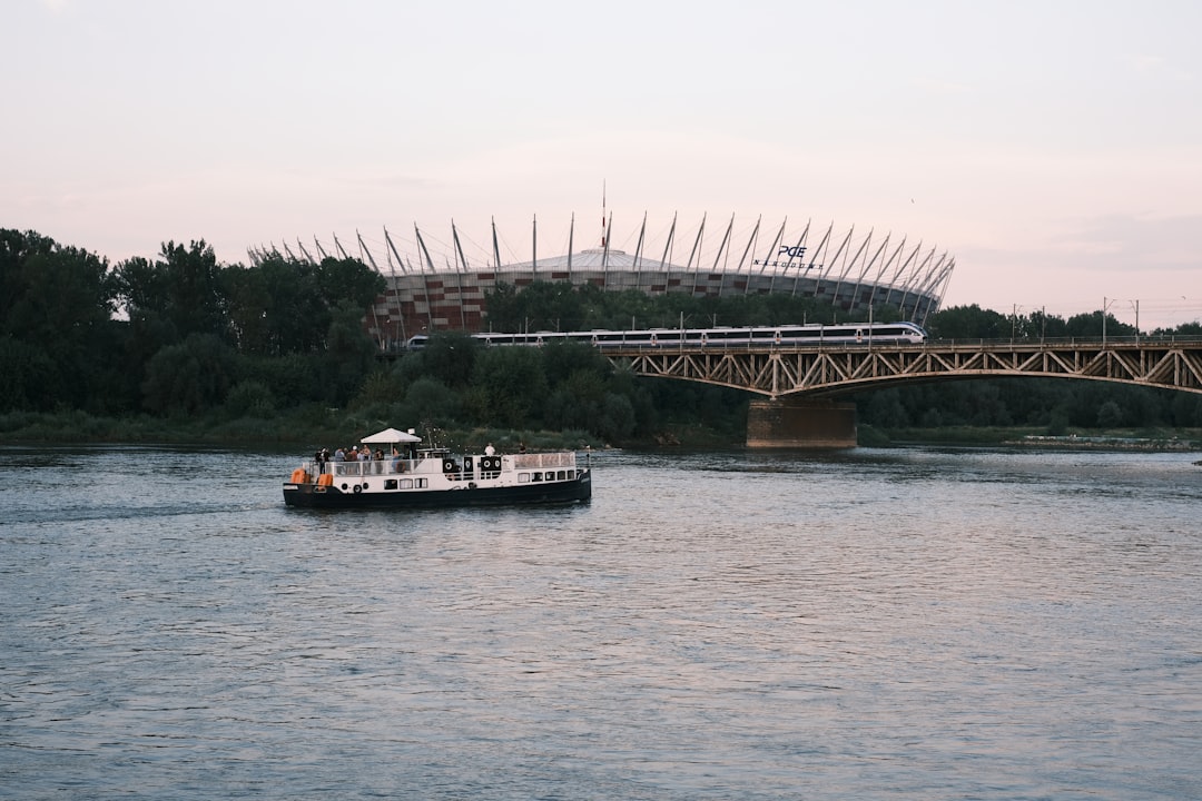 a boat traveling down a river under a bridge,