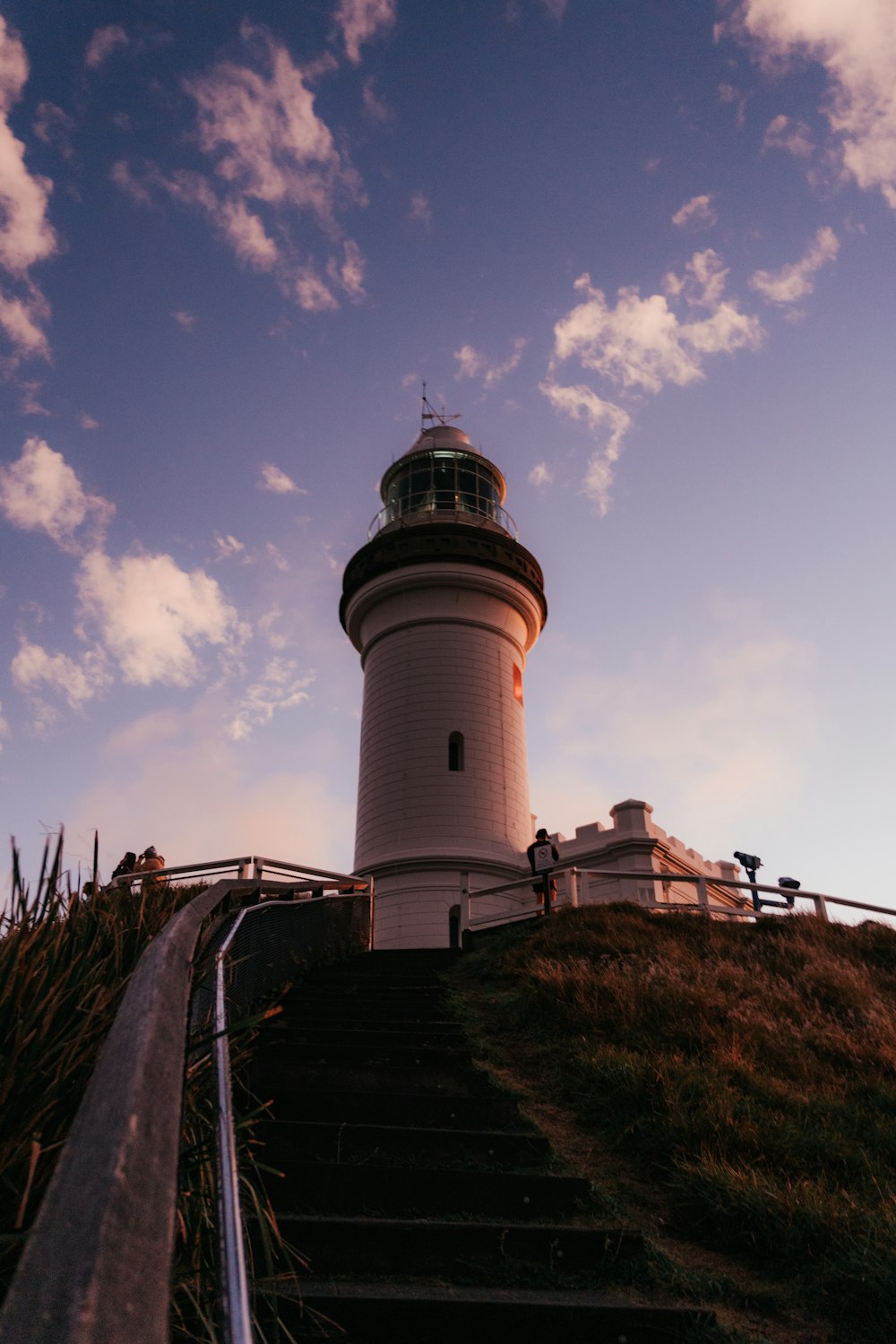 a lighthouse on top of a grassy hill