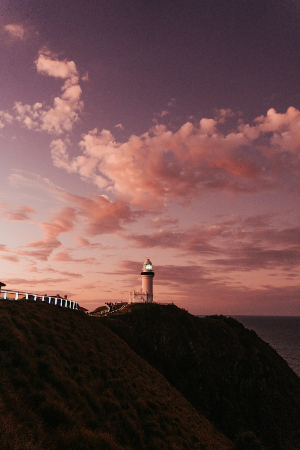 a lighthouse on top of a hill near the ocean